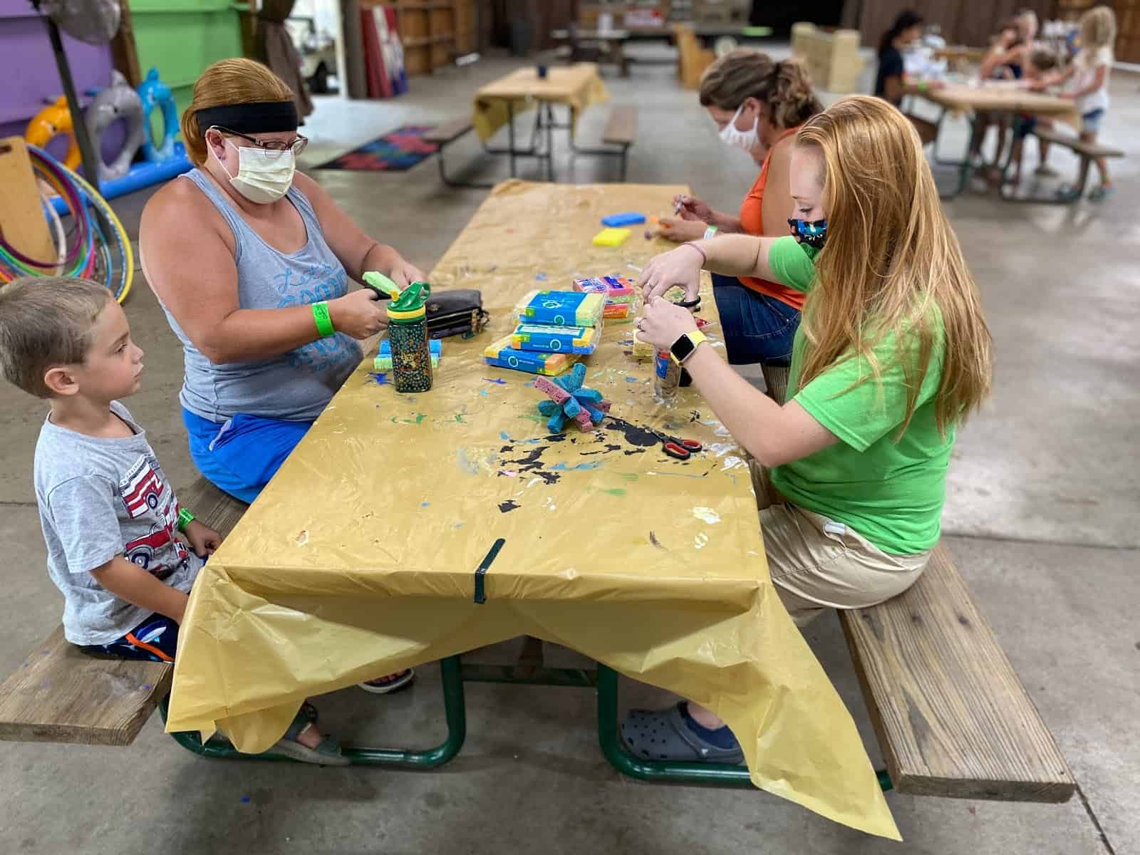A group of people sitting at a table making crafts.