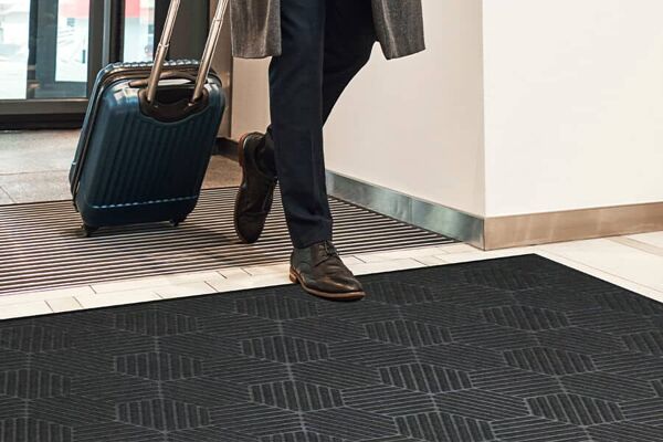 WaterHog Silver in place indoors 4x6 graphite Floormat.com <strong>WaterHog Silver</strong> mats feature the unique bi-level design that made WaterHog mats famous, with a new anti-microbial surface that reduces bacteria growth by 99%! <ul> <li><strong>Anti-Microbial</strong> - Woven with a unique silver ion anti-microbial fiber, WaterHog Silver mats offer added protection from odor-causing bacteria</li> <li><strong>Dirt & Moisture Control</strong> - Bi-level surface effectively scrapes dirt and moisture from shoes, trapping it beneath shoe level to prevent tracking; water dam border holds moisture keeping it off your floors (WaterHog mats can hold up to 1.5 gallons of water per square yard)</li> <li><strong>Durable</strong> - Reinforced rubber nubs prevent pile from crushing and extend the performance life of the mat Fade & Stain Resistant - Solution-dyed PET fabric (30 ounces per square yard) is resistant to staining, dries quickly, and will not fade or rot</li> <li><strong>Safe</strong> - Beveled edges provide a safe transition from floor to mat; WaterHog products are certified high traction by the National Floor Safety Institute (NFSI)</li> <li><strong>Eco-Friendly</strong> - SBR rubber backing contains 20% post-consumer recycled rubber from car tires; PET surface is made from 97% recycled materials</li> <li>Available in colors with choice of classic (rubber) border</li> <li>Feature 78-mil SBR rubber with universal cleated backing or smooth backing</li> </ul> <em>WaterHog Silver features a zirconium phosphate-based ceramic ion-exchange resin that contains silver. This resin is effective against a broad spectrum of microorganisms that cause discoloration, odor, biofouling, and other aesthetic problems. In independent tests conducted by The MicroStar Lab, WaterHog Silver reduced bacteria growth by more than 99%. During testing, WaterHog Silver mat swatches are placed in a sterile container, inoculated with bacteria^, and incubated for a specified time. After incubation, colonies of recovered bacteria are counted and used to determine percent reductions. In the WaterHog Silver test, less than 1% of the bacteria remained; more than 99% had been reduced.</em> <em>^Specifically the klebsiella pneumoniae and staphylococcusaureus bacteria</em> Please note, mat sizes are approximate as rubber shrinks and expands in conjunction with temperature and time. Tolerable manufacturing size variance is 3-5%. <strong>Specifications</strong> SURFACE Material: Solution-dyed PET (polyethylene terephthalate) featuring zirconium phosphate-based ceramic ion-exchange resin containing silver. Weight: 30 ounces/yard2 Construction: Needle-punched Design: Honeycomb BACKING OPTIONS Material: SBR rubber - smooth or universal cleated Thickness: 78-mil (body thickness 78-mil; border thickness 143-mil) OVERALL MAT THICKNESS: 3/8 inch (0.375") STANDARDS & TESTING Certified high-traction by the National Floor Safety Institute (NFSI) Passes CPSC FF 1-70 for the surface flammability of carpets <strong>Cleaning Instructions</strong> For the best results, utilize the following cleaning method to clean your WaterHog mat: Vacuum regularly (daily in high-traffic commercial areas; weekly in lower traffic areas). Extract or hose off as needed to remove heavy soil/debris. Hang mat to dry. Always make sure the mat is dry before placing it back in service.